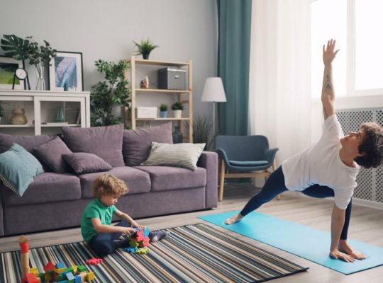 a woman and a child doing yoga in a living room