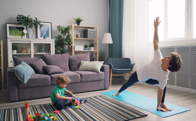 a woman and a child doing yoga in a living room